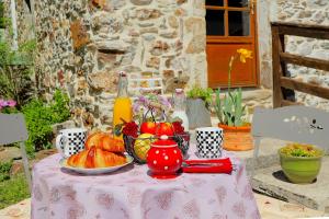 a table with a bowl of fruit on top of it at Gîte Mas La Tabatière in Chamborigaud