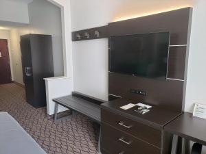 a hotel room with a flat screen tv and a dresser at Holiday Inn Express San Angelo, an IHG Hotel in San Angelo