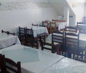 a dining room with tables and chairs with white table cloth at Pousada Brasil - Self Check-in in Aparecida