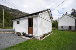 a small white house with a grass yard at Songesand Camp in Songesand