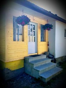 a porch of a house with stairs and windows at Bodziuchówka in Mizerna