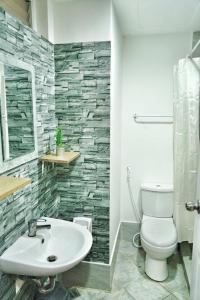 a bathroom with a white toilet and a sink at ANIA CONDO STAY in Mactan +45 photos