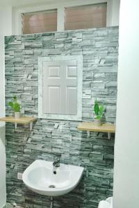 a bathroom with a sink and a stone wall at ANIA CONDO STAY in Mactan