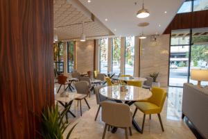 a restaurant with tables and chairs and windows at mawasim al hay at hotel in Jeddah