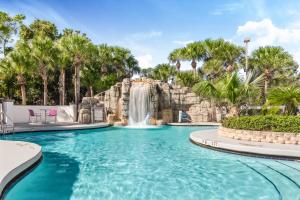 a swimming pool with a waterfall in a resort at Crowne Plaza Orlando - Lake Buena Vista, an IHG Hotel in Orlando