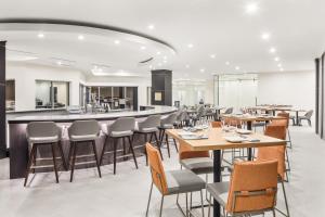 Un restaurante con mesas y sillas y un bar. en Crowne Plaza Orlando - Lake Buena Vista by IHG, en Orlando