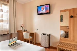 ein Hotelzimmer mit einem Laptop auf dem Tisch in der Unterkunft Hotel Postumia in Dossobuono