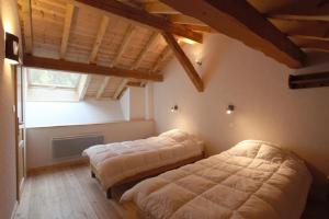 a bedroom with two beds and a large window at Les Cabasses 6 - Accommodation in a village house in Villar-dʼArène