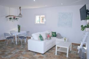 ein Wohnzimmer mit einer weißen Couch und einem Tisch in der Unterkunft SWEET HOUSE in Santa Margalida
