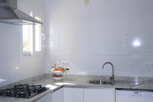 eine weiße Küche mit einer Spüle und einem Herd in der Unterkunft SWEET HOUSE in Santa Margalida
