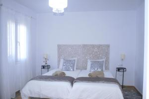 Schlafzimmer mit einem großen weißen Bett mit Kopfteil in der Unterkunft SWEET HOUSE in Santa Margalida