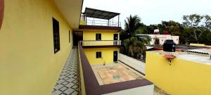 a view of a yellow building with a balcony at HOTEL VILLA CALAKMUL in Xpujil
