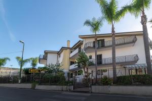 a building with palm trees in front of a street at Hotel Il Ceppo in Agropoli