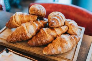 a pile of croissants on a wooden cutting board at The Park Hotel in Teddington