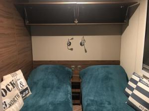 - 2 lits dans une petite chambre avec des draps verts dans l'établissement Luxueux mobilhome 6 à 8 p Saint Brévin Les Pierres Couchées, à Saint-Brévin-les-Pins