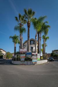 una calle con palmeras frente a una casa en Hotel Il Ceppo, en Agropoli