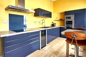 een grote keuken met blauwe kasten en een wastafel bij Apt 1 ch - Centre ville Vannes - Gare à pied - Parking in Vannes