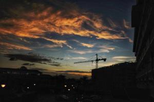 a sunset with a crane in a city at ANIA CONDO STAY in Mactan