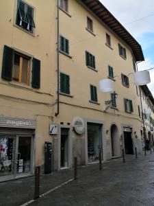 un gran edificio con persianas verdes en una calle en Pontassieve Guest House centro storico camera con bagno 20 minuti da Firenze, en Pontassieve