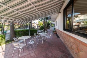 patio ze stołami i krzesłami pod markizą w obiekcie Hotel Il Ceppo w Agropoli