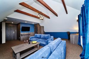 a living room with a blue couch and a table at Gościniec pod Strzechą in Suwałki