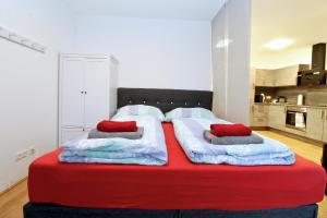 1 cama grande roja y blanca con 2 almohadas en Balcony/pool/free parking garage Studio, en Viena 29 fotos más