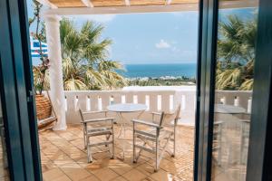 un patio con tavolo, sedie e vista sull'oceano di Villa Ippocampi - Adults Only a Hersonissos