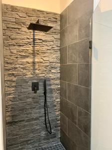 a bathroom with a shower with a stone wall at Victoria's House in Lille