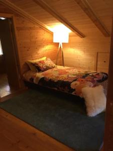 a bedroom with a bed in a wooden cabin at B&B Casa PerAria in Paluzza
