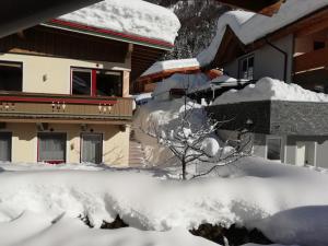 a pile of snow in front of a house at Ferienwohnung Kogler in Waidring