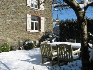 een tafel en stoelen in de sneeuw naast een gebouw bij Bordo Village in Bièvre