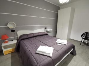 a bedroom with a bed with two towels on it at IL FEUDO in Sellia Marina
