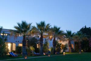 a view of a resort with palm trees at night at Mangio Fango Hotel et Spa in Saintes-Maries-de-la-Mer