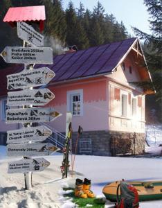 a sign in the snow in front of a house at Chalupa u Jakuba in Liptovské Revúce