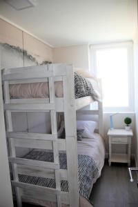 um beliche branco num pequeno quarto em Concón Costa de Montemar Departamento, 3 dormitorios em Concón