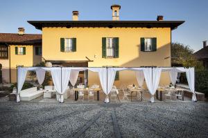 un locale all'aperto con tende e tavoli bianchi e un edificio di Hotel Morimondo a Morimondo