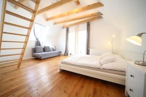um quarto com uma cama grande e pisos em madeira em Hofhaus mit Riesengarten - gemütliches Häuschen im Kern des schönsten Mainzer Stadtteils Finthen em Mainz