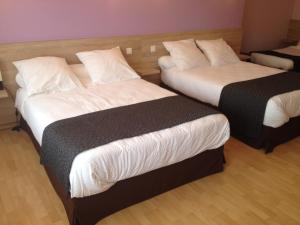 A bed or beds in a room at Hôtel Restaurant du Lauragais LOGIS DE FRANCE