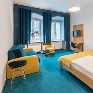 a hotel room with a bed and a couch and chairs at TCZ Woźna in Poznań