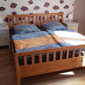 a wooden bed with a wooden frame and two pillows at Ferienwohnung Müller in Bestwig