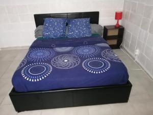 uma cama com um edredão azul e almofadas em Boulevard Paul Valéry em Montpellier