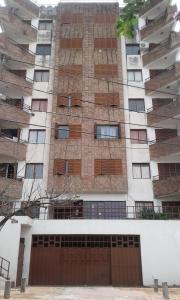 ein hohes Gebäude mit einem braunen Tor davor in der Unterkunft Departamento Centro Villa Carlos Paz in Villa Carlos Paz