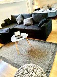 - un salon avec un canapé noir et une table dans l'établissement DP Apartments Vaasa II, à Vaasa