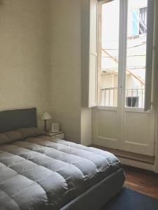 sypialnia z dużym łóżkiem i oknem w obiekcie CASA FISCARDI w mieście Bari