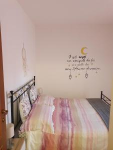 a bedroom with a bed with a quote on the wall at Mary House in Ladispoli