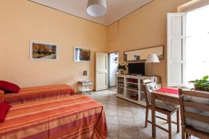 een slaapkamer met een bed, een bureau en een televisie bij All' Ombra Del Duomo in Florence