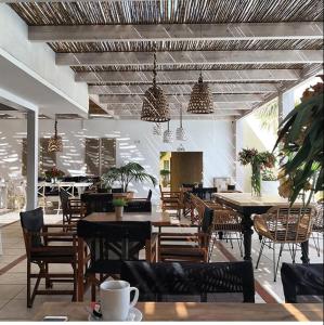 um restaurante com mesas e cadeiras de madeira e mesas e cadeiras em Danaides em Malia