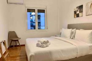 Un dormitorio con una cama blanca con toallas. en Kallimarmaro 2-Bedroom Apartment en Atenas