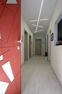 un pasillo vacío en un edificio de oficinas con una puerta roja en Villa Joy - Iconic Heritage Rooms, en Montesilvano