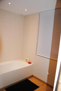 a white bathroom with a tub and a window at G-63 - Appartement de standing en plein coeur d'Hossegor in Soorts-Hossegor